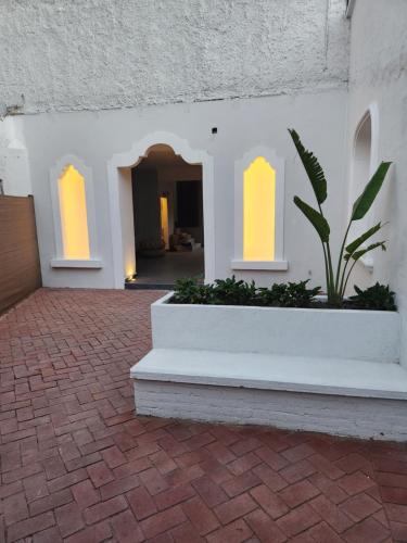 a white building with two windows and a potted plant at Villa Escondida in Guadalajara