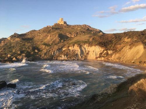 un faro en la cima de una montaña junto a una playa en 1 Apartment D3 Home, en Palma di Montechiaro
