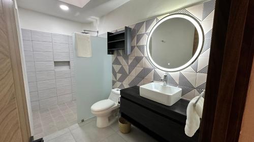 a bathroom with a sink and a mirror and a toilet at Villa Escondida in Guadalajara