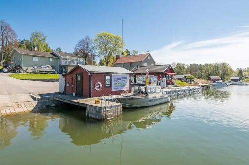 a small boat is docked at a dock on the water at Skärgårdslägenhet med havsutsikt i Sankt Anna! NR1 in Sankt Anna