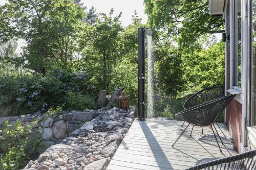 a porch with a bench and a rock wall at Skärgårdslägenhet med havsutsikt i Sankt Anna! NR1 in Sankt Anna