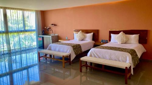 a hotel room with two beds and a window at Hotel Wellness - Belleza y Serenidad in Boca del Río