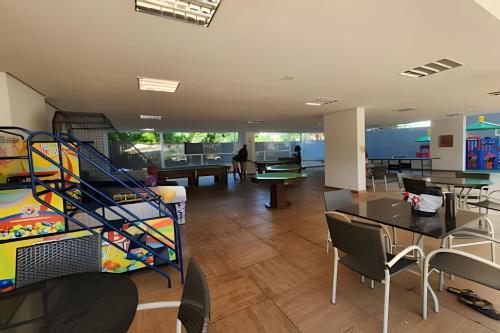 a room with tables and chairs and a staircase at Apartamentos em Rio Quente com maravilhosa área de lazer e excelente localização in Rio Quente