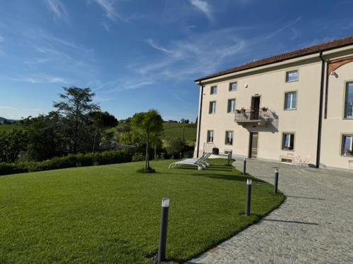 a large building with a grass yard in front of it at Ermitage la suite-hermitage al tramonto-Hermitage tra le vigne in Cioccaro