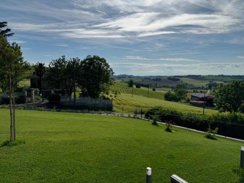 a field of green grass with a fence and trees at Ermitage la suite-hermitage al tramonto-Hermitage tra le vigne in Cioccaro
