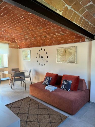 a living room with a couch and a clock on the wall at Ermitage la suite-hermitage al tramonto-Hermitage tra le vigne in Cioccaro