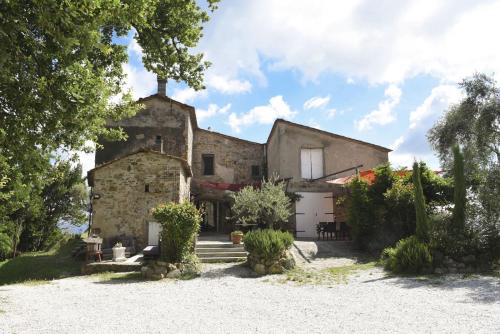 an exterior view of a large stone house with trees at Società agricola Scerba srl in Montemagno