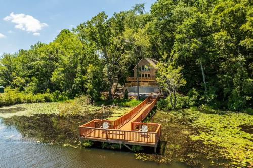 a wooden dock in the water with a house in the background at Brand-New Perry House with Kayaks and Lake Access in Perry