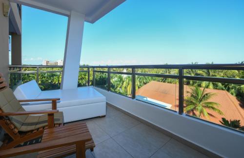 a balcony with a couch and a chair at El Dorado Seaside Palms, Catamarán, Ecoturistic Ranch, All & More Inclusive - Adults Only in Akumal