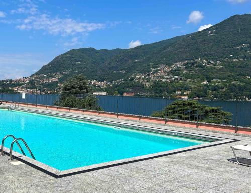 a swimming pool with a mountain in the background at Nest Blevio apartment with private garage in Blevio