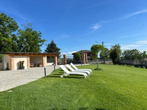 a group of white chairs sitting on the grass at Ermitage la suite-hermitage al tramonto-Hermitage tra le vigne in Cioccaro