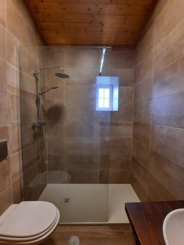 a bathroom with a shower with a toilet and a sink at Casa Primavera in Alcoutim