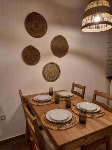 a wooden table with plates and baskets on the wall at Casa Primavera in Alcoutim