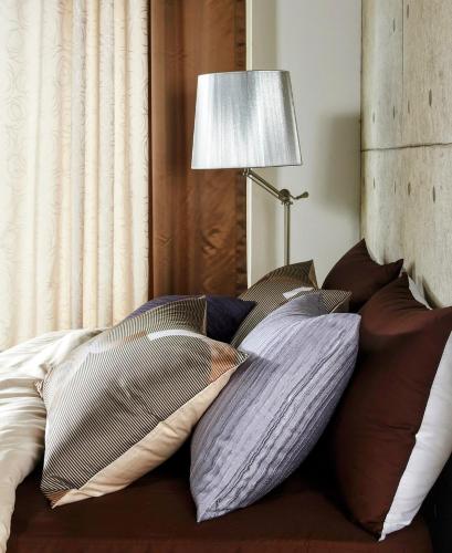 a bed with four pillows on it with a lamp at Guest room in Lucan