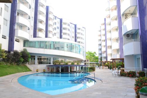 a hotel with a swimming pool in front of a building at Prime Hotel Águas da Serra in Rio Quente