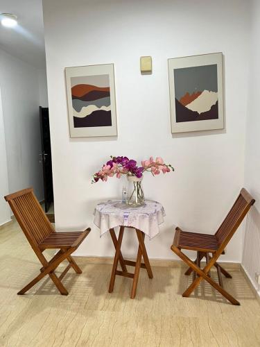 two chairs and a table with a vase of flowers at Residence Roume Abidjan Plateau in Abidjan