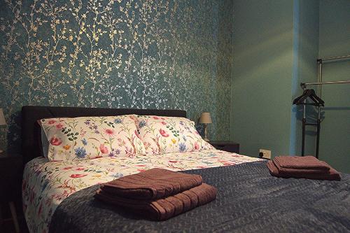a bedroom with a bed with a floral wallpaper at Dreamstay Apartments London Garden Central Tube Olympic in London