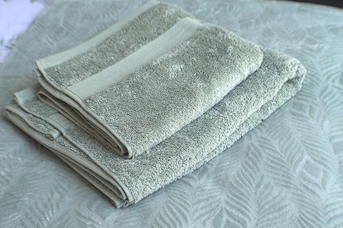 a stack of towels sitting on top of a bed at Dreamstay Apartments London Garden Central Tube Olympic in London