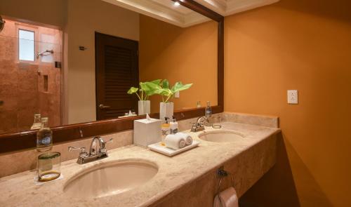 a bathroom with two sinks and a large mirror at El Dorado Seaside Palms, Catamarán, Ecoturistic Ranch, All & More Inclusive - Adults Only in Akumal