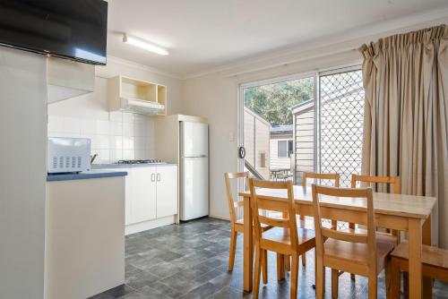 a kitchen and dining room with a table and chairs at Echo Holiday Parks - Windsor Gardens in Adelaide