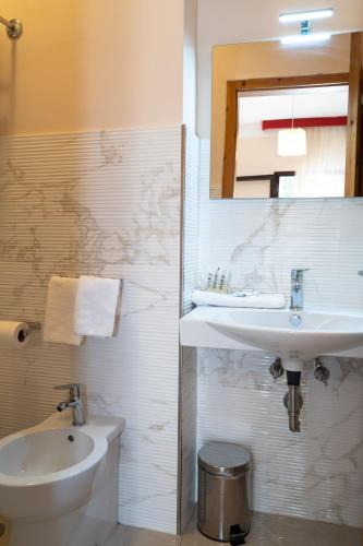 a white bathroom with a sink and a toilet at Residence Cilento in Marina di Camerota