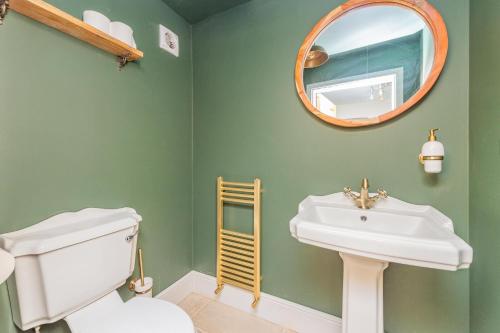 un bagno con un lavandino bianco e uno specchio di Mill Cottages Shrewsbury With Hottub a Merrington