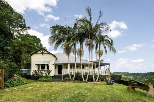 a white house with palm trees in front of it at Beam Creek Cottage - Montville in Montville