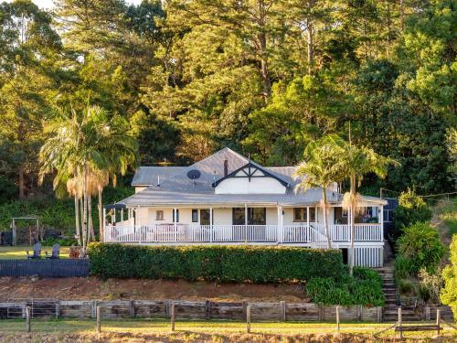 a white house with a fence and trees at Beam Creek Cottage - Montville in Montville