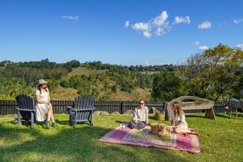 three people sitting on a picnic blanket in the grass at Beam Creek Cottage - Montville in Montville