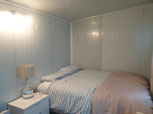 a bedroom with a bed and a lamp on a night stand at C2 Save money budget affordable cabin with comfort! - Cabin2 in Auckland