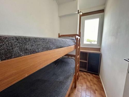 Ce lit superposé se trouve dans un dortoir doté d'une fenêtre. dans l'établissement Studio cabine avec piscine, terrasse et parking – 4 couchages à Saint-Cyprien Plage - FR-1-225D-212, à Saint-Cyprien