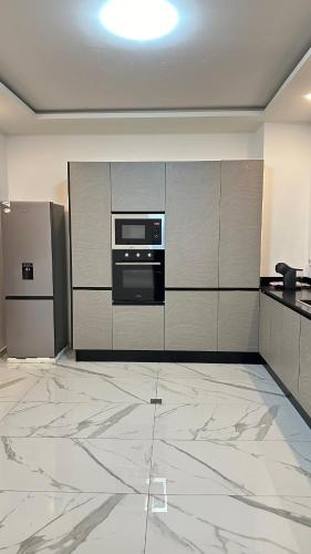 a kitchen with a stove and a microwave at Residence Roume Abidjan Plateau in Abidjan
