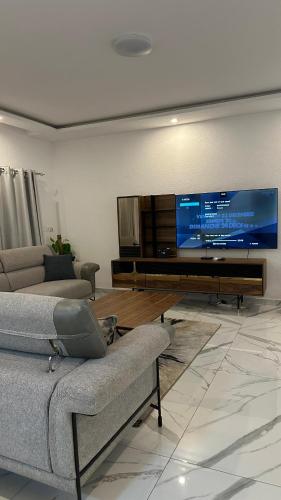 a living room with a large flat screen tv at Residence Roume Abidjan Plateau in Abidjan