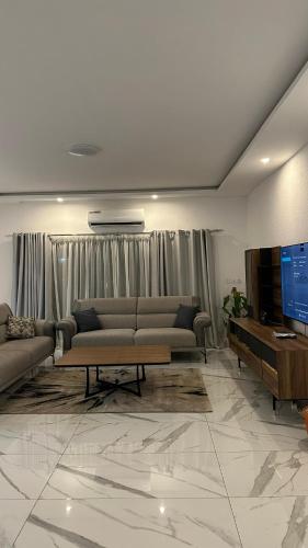 a living room with two couches and a tv at Residence Roume Abidjan Plateau in Abidjan