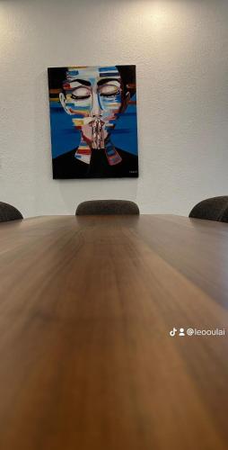 a table with two chairs in front of a painting at Residence Roume Abidjan Plateau in Abidjan