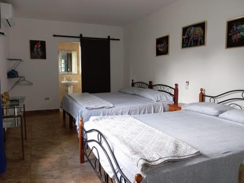 a room with three beds and a sink in it at Little Italy B&B in Boquerón