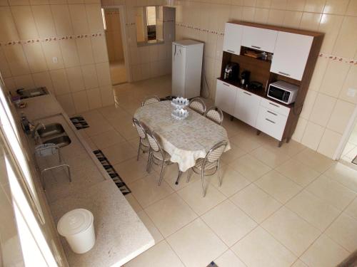 a kitchen with a table with chairs and a refrigerator at Aluga-se casa para Temporada in Águas de Lindóia