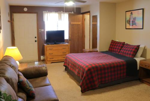 レッドリバーにあるAspen West Deluxe 3 - On Main St - Fireplace - Washer - Dryer - Grillのベッドとソファとテレビのある寝室
