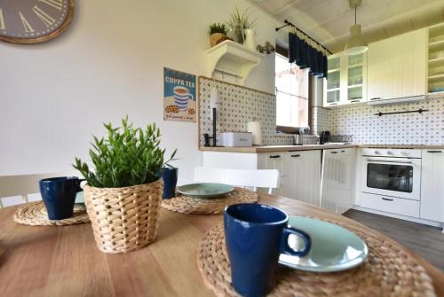 una cucina con un tavolo di legno con sopra delle tazze blu di Domek na Kaszubach 19-1 - Ostoja Bukowo a Borowy Młyn