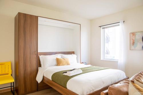 密尔沃基Sunlit Modern Apartment with Balcony的卧室里有一张带木质床头板的大床