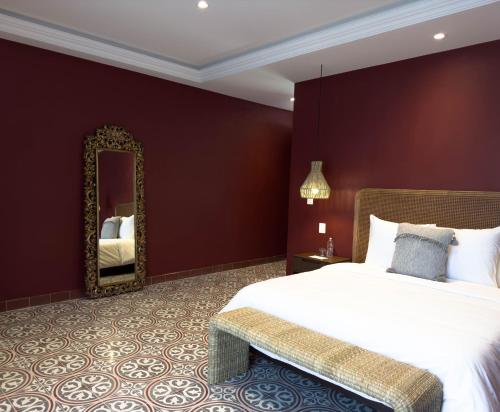 a bedroom with a large bed and a mirror at Casa Martina Guest House in Pátzcuaro