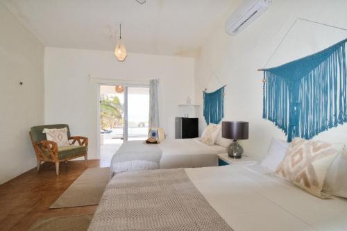 a hotel room with two beds and a chair at Arena y Mar Beachfront House, El Cuyo by The Spot Rentals in El Cuyo