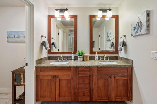 a bathroom with two sinks and two mirrors at Pili Mai 15H - Central A/C in Kipu