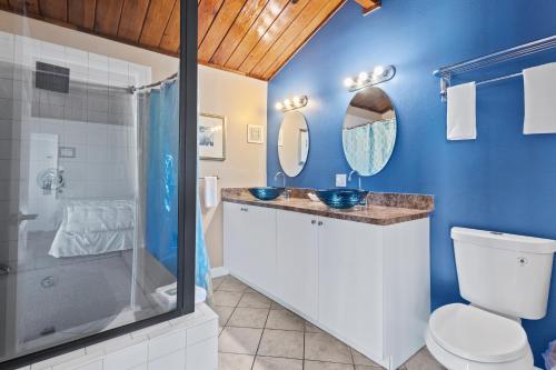 フォートピアースにあるOceanfront Inn Suite, Ocean and Inlet Views, King Bed, #12の青いバスルーム(トイレ、シャワー付)