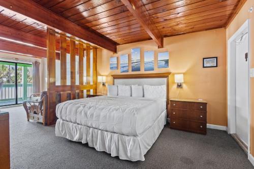 a bedroom with a large bed and a wooden ceiling at Fort Pierce Oceanfront Inn- Suite- King Bed #6 in Fort Pierce