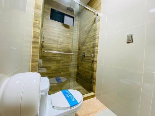 a bathroom with a toilet and a shower at Departamento 2Hab con Patio & Parrillera - A 10min del Consulado Americano in Guayaquil