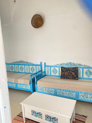 two beds in a room with blue and white at Le bien être in Kelibia