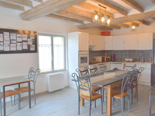 une cuisine et une salle à manger avec tables et chaises dans l'établissement Grande maison familiale avec jardin, terrasse et équipements de loisirs, proche forêt de la Charnie - FR-1-410-297, à Chemiré-en-Charnie
