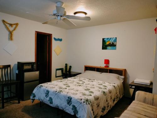 ロートンにあるGolden Sunflower's Apt B1のベッドと天井扇風機のある寝室