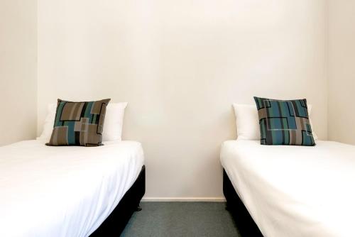 two beds sitting next to each other in a room at Echo Holiday Parks - Windsor Gardens in Adelaide